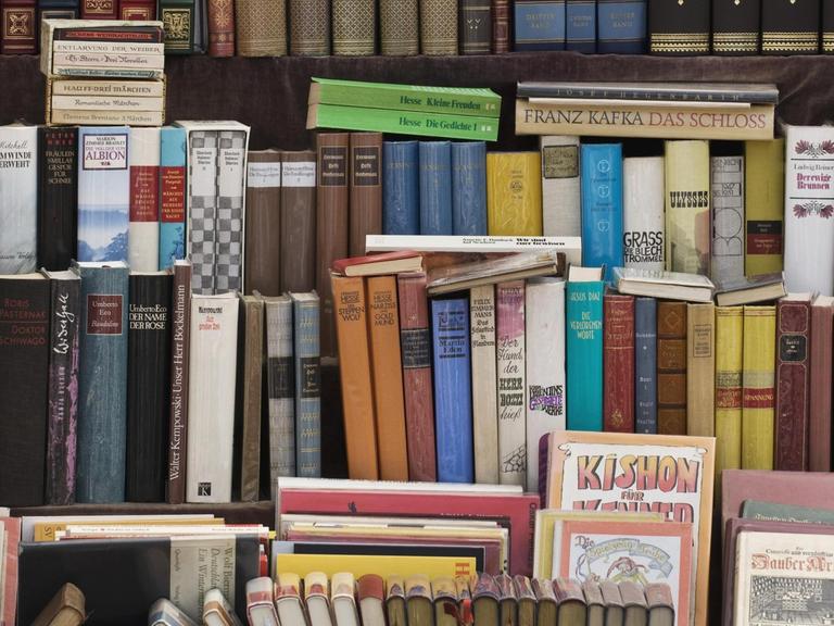 Alte Bücher stehen in der Auslage eines Antiquariats.