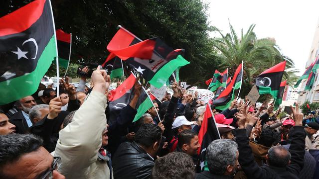 Menschen schwenken libysche Flaggen auf der Straße
