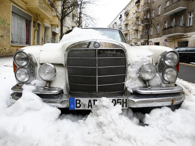 Ein eingeschneiter Oldtimer in Berlin Friedrichshain.