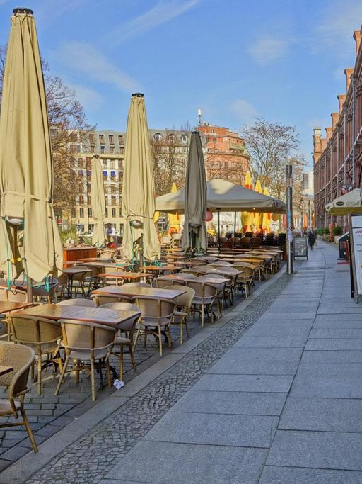 Wegen des Coronovirus verwaister Hackescher Markt mit leeren Restauranttischen und geschlossenen Sonnenschirmen am hellen Tag in Berlin-Mitte am 18.03.2020