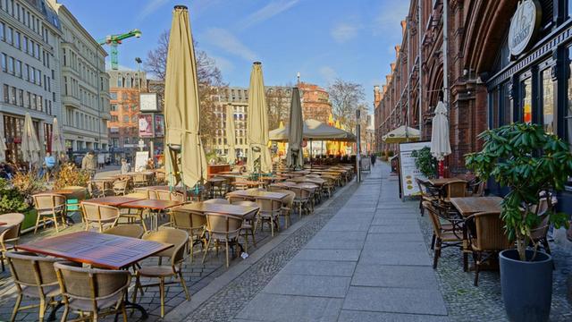 Wegen des Coronovirus verwaister Hackescher Markt mit leeren Restauranttischen und geschlossenen Sonnenschirmen am hellen Tag in Berlin-Mitte am 18.03.2020
