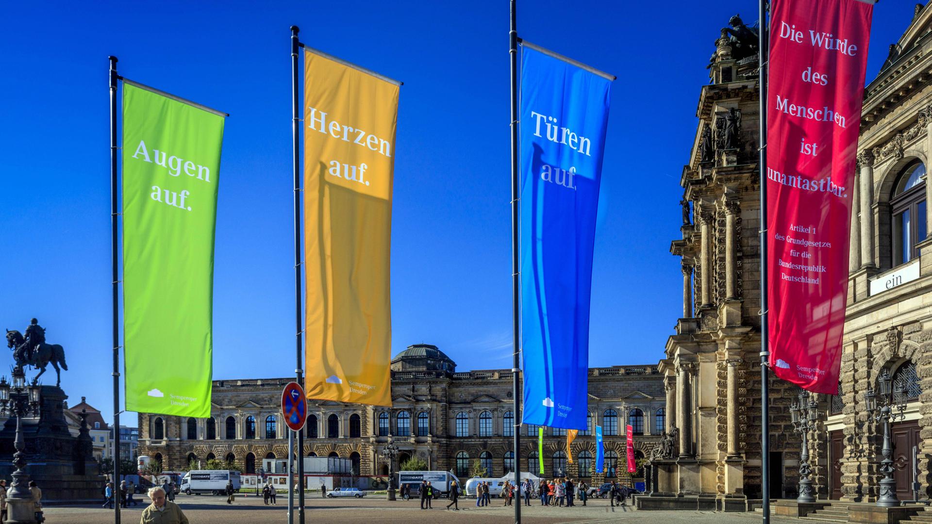 Dresden für Weltoffenheit: "Augen auf", "Herzen auf", "Türen auf", "Die Würde des Menschen ist unantastbar" steht auf bunten Fahnen vor der Semperoper Dresden für Weltoffenheit: "Augen auf", "Herzen auf", "Türen auf", "Die Würde des Menschen ist unantastbar" steht auf bunten Fahnen vor der Semperoper