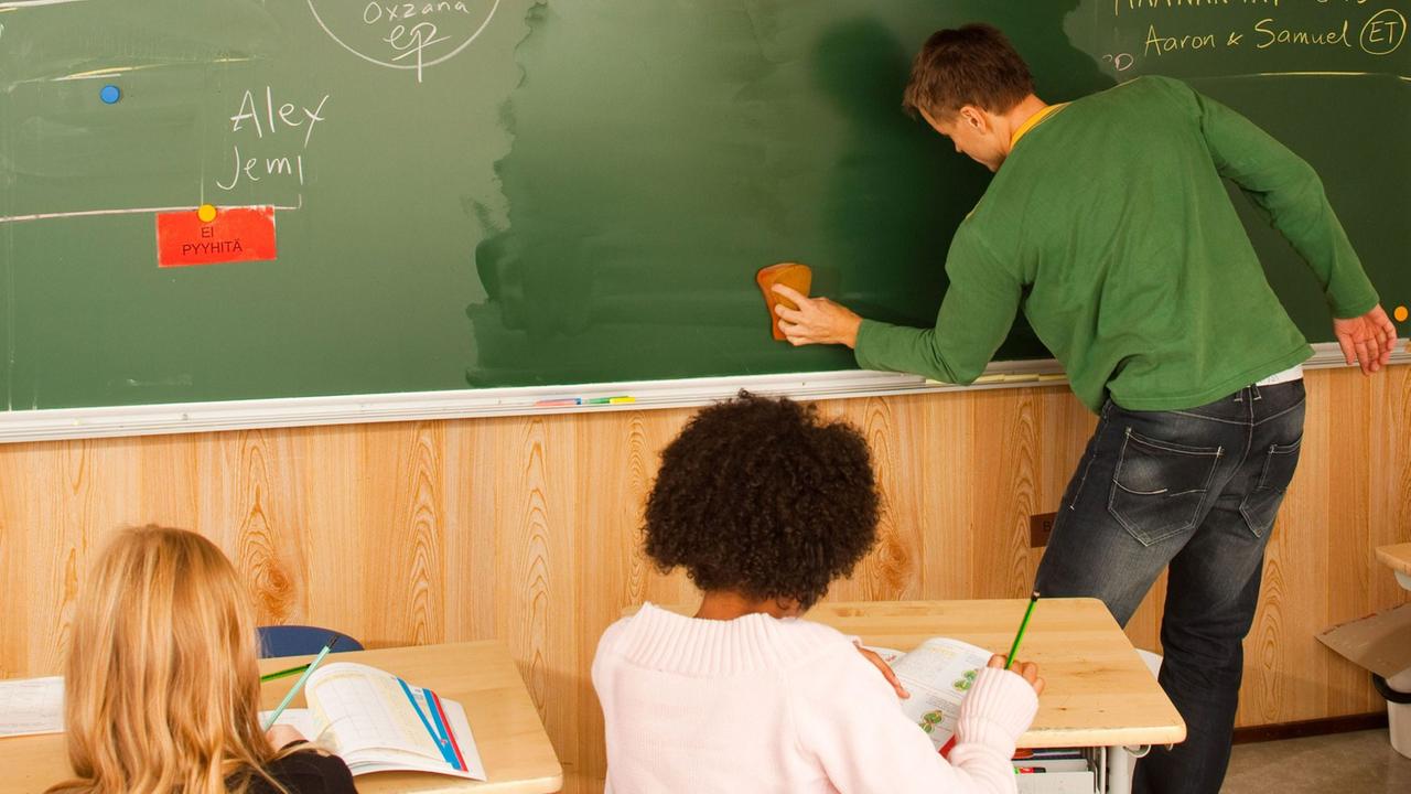 Unterricht in einer finnischen Schule. Ein Lehrer steht an der Tafel.