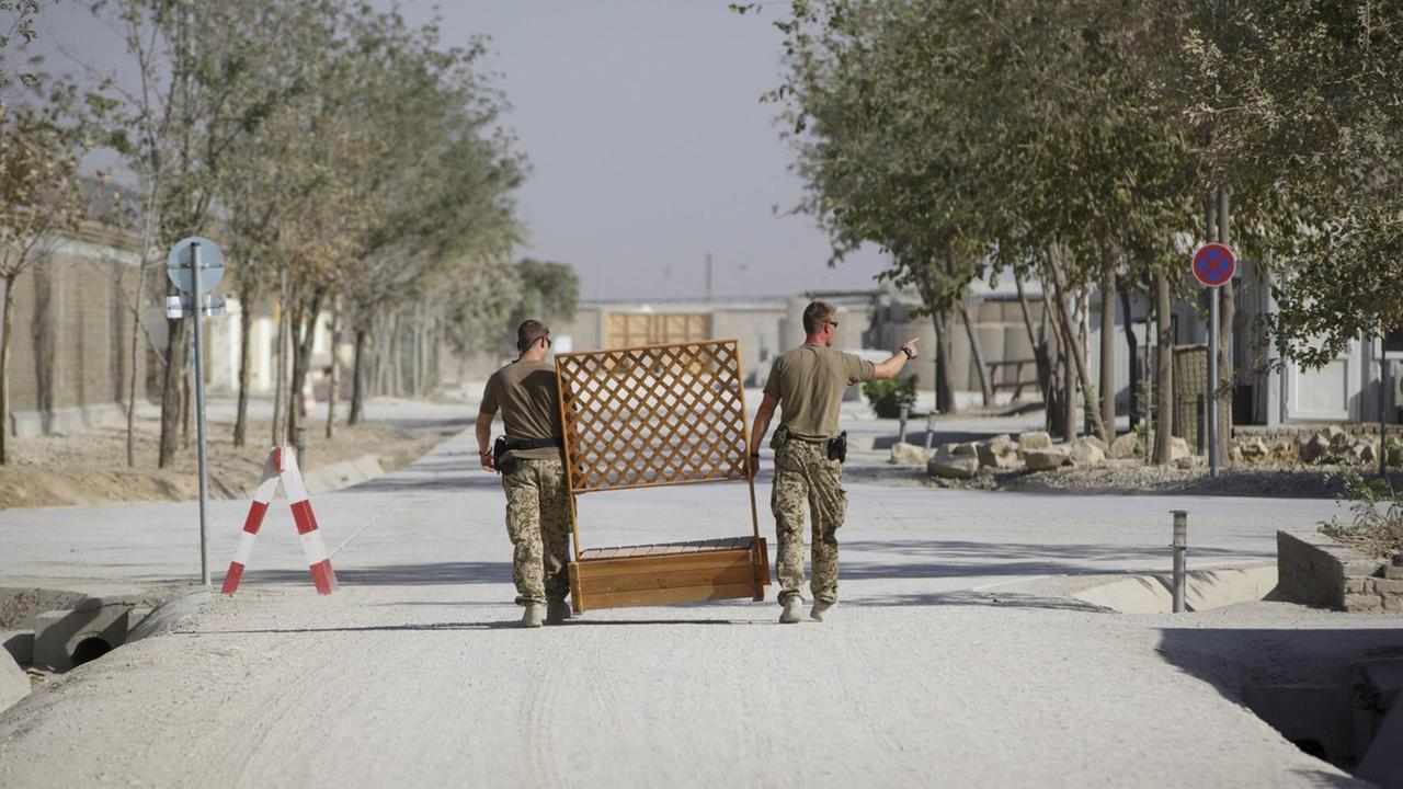 Soldaten der Bundeswehr in Kundus tragen einen Holzzaun. Soldaten der Bundeswehr in Kundus tragen einen Holzzaun.