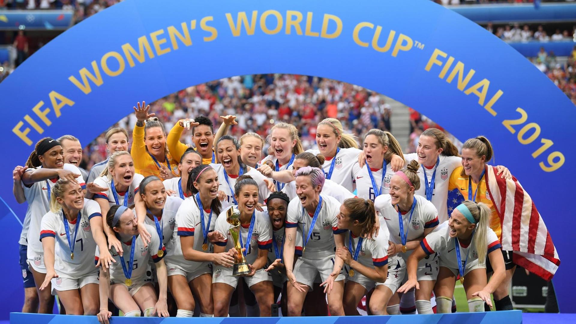 Carli Lloyd (M) hält den WM-Pokal inmitten der jubelnden US-Spielerinnen.