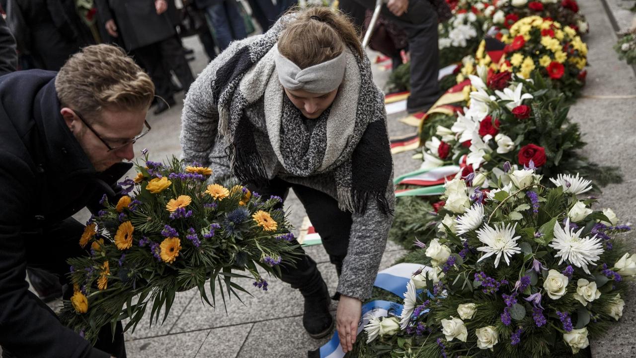 Menschen legen am Berliner Breitscheidplatz Blumen nieder, um an die Opfer des Anschlags vor zwei Jahren zu erinnern. 
