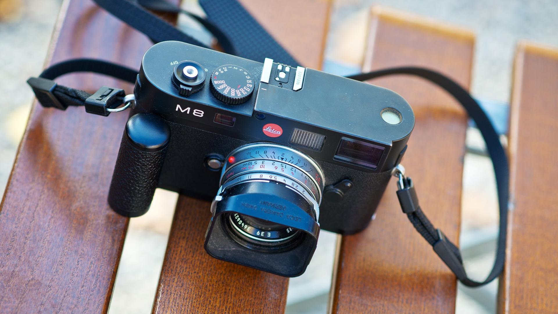Eine Leica-Kamera liegt auf einem Stuhl Eine Leica-Kamera liegt auf einem Stuhl