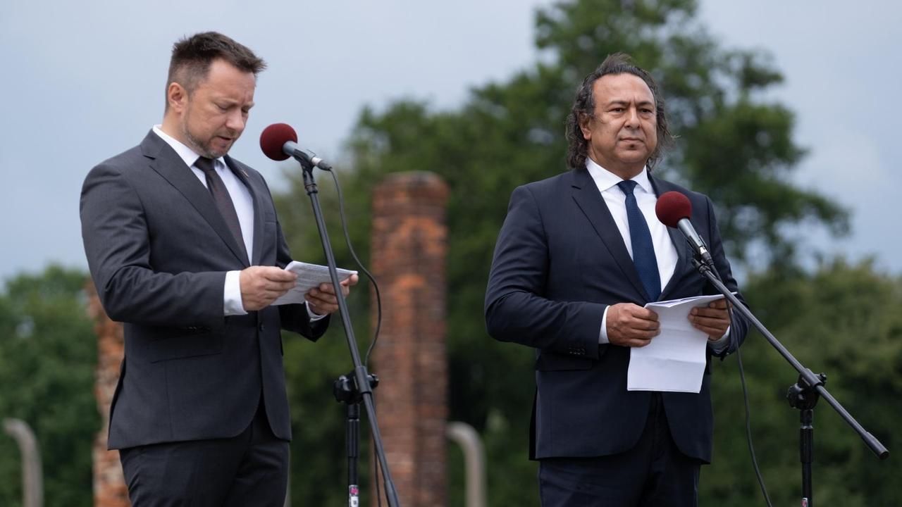 Roman Kwiatkowski (r.), der Vorsitzende des polnischen Roma-Verbands und Kamil Majchrzak, Vorstandsmitglied des Internationalen Komitees Buchenwald-Dora, in Anzug vor Mikrofonen Roman Kwiatkowski (r.), der Vorsitzende des polnischen Roma-Verbands und Kamil Majchrzak, Vorstandsmitglied des Internationalen Komitees Buchenwald-Dora, in Anzug vor Mikrofonen