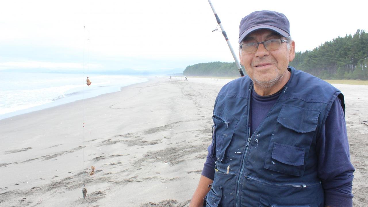 Angler José Nuñez steht am Strand neben der Fabrik von Arauco. Angler José Nuñez steht am Strand neben der Fabrik von Arauco.