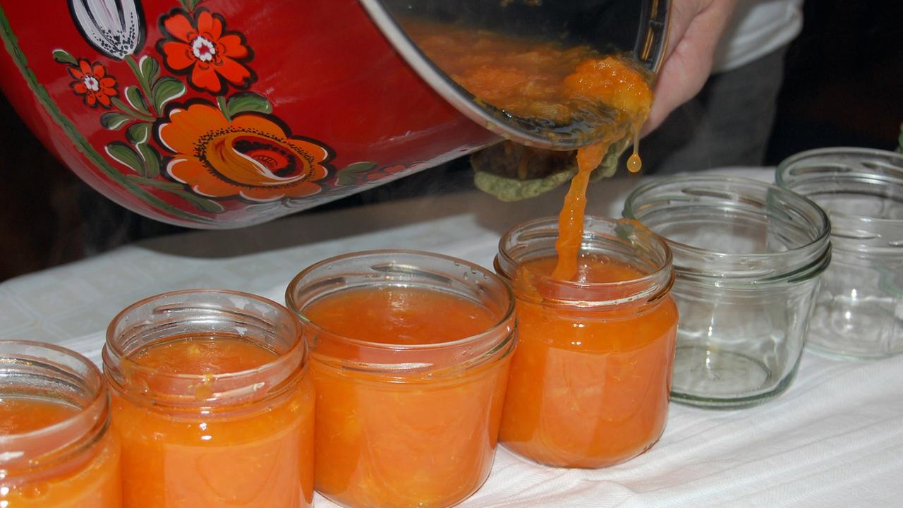 Selbstgemachte Marmelade wird in Gläser abgefüllt Selbstgemachte Marmelade wird in Gläser abgefüllt
