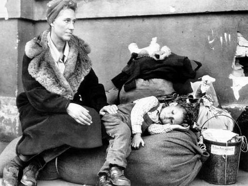 Flüchtlinge warten im Oktober 1945 auf einen Zug.