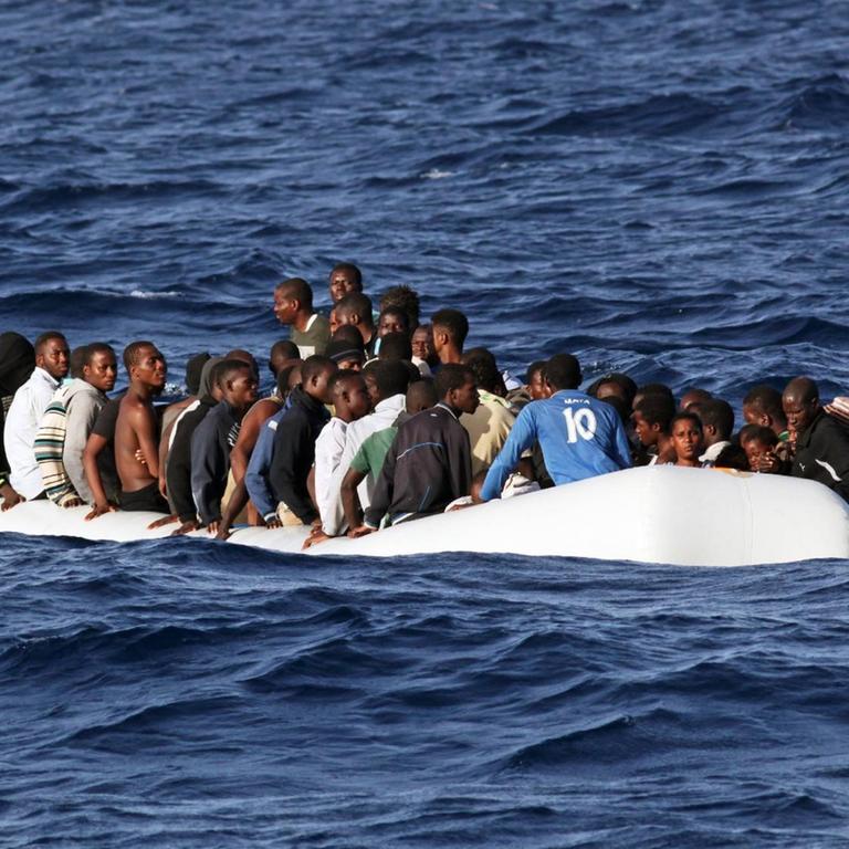 Ein mit Menschen überfülltes Schlauchboot treibt auf dem Mittelmeer.
