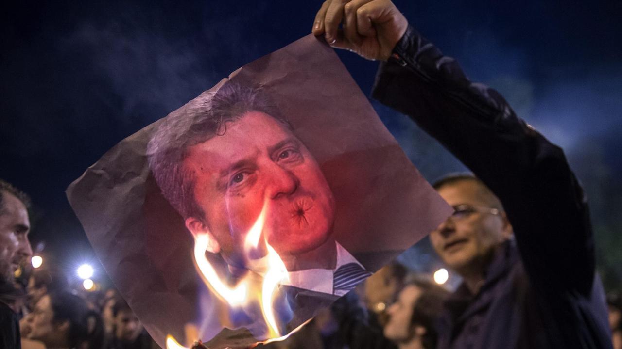 Demonstranten verbrennen ein Bild des mazedonischen Präsidenten Gjorge Ivanov. 