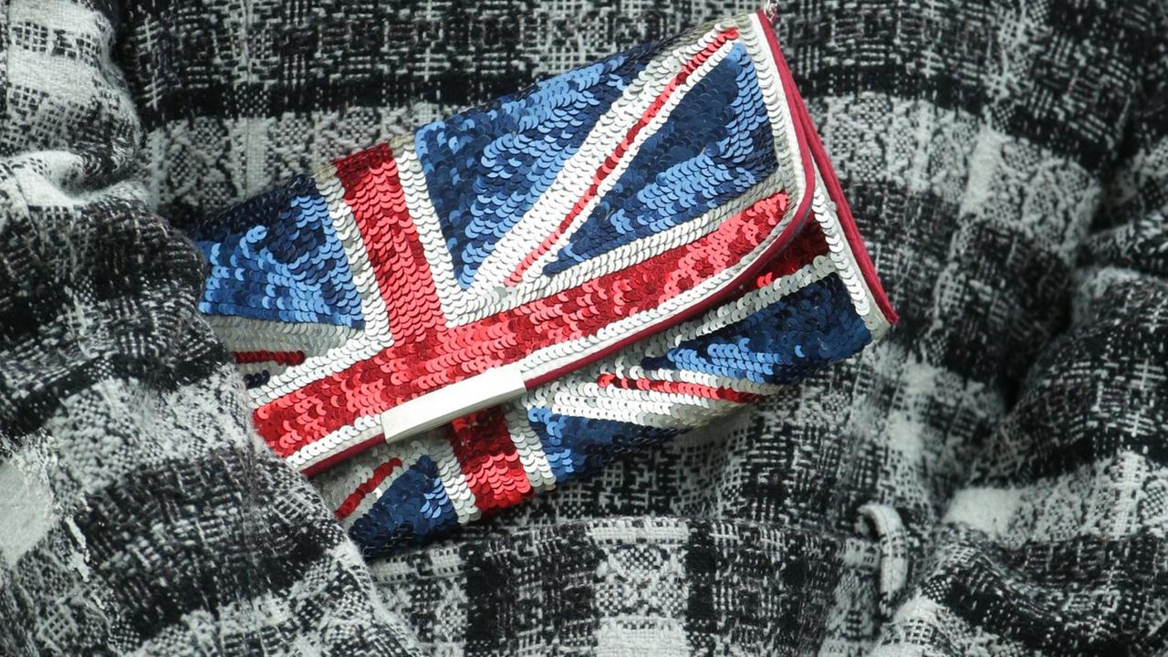 Eine Frau mit einer Handtasche (Clutch) in britischen Farben steht während des Besuchs von Königin Elizabeth II am Spreeufer in Berlin. Eine Frau mit einer Handtasche (Clutch) in britischen Farben steht während des Besuchs von Königin Elizabeth II am Spreeufer in Berlin.