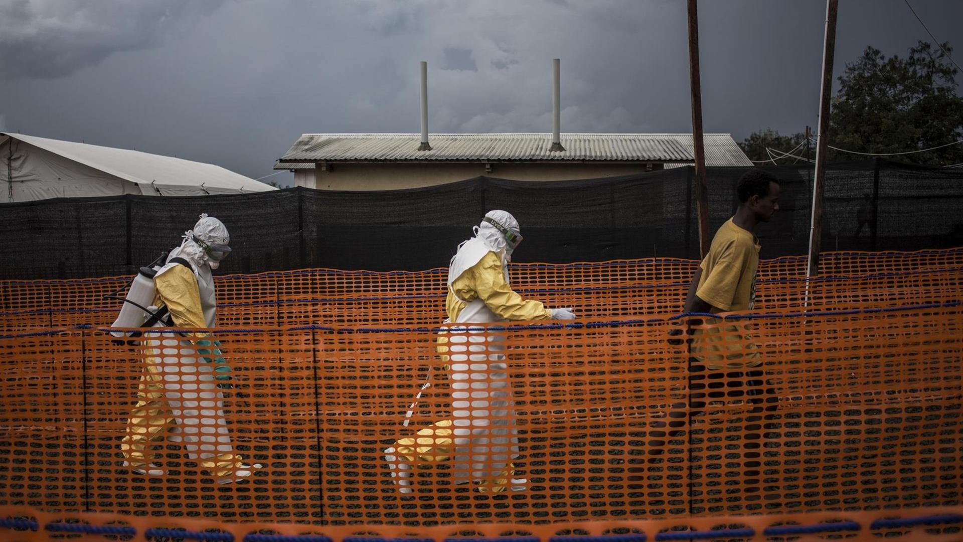 Mitarbeiter der Gesundheitsdienste mit einem Ebola-Patienten in einem speziellen Zentrum in Bunia in der Demokratischen Republik Kongo. Mitarbeiter der Gesundheitsdienste mit einem Ebola-Patienten in einem speziellen Zentrum in Bunia in der Demokratischen Republik Kongo.