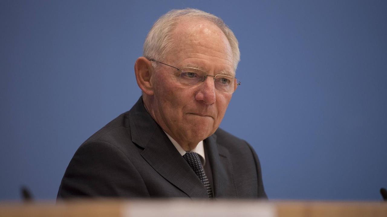 Wolfgang Schäuble mit konzentriertem Blick und verkniffenem Mund vor der blauen Wand der Bundespressekonferenz. Wolfgang Schäuble mit konzentriertem Blick und verkniffenem Mund vor der blauen Wand der Bundespressekonferenz.