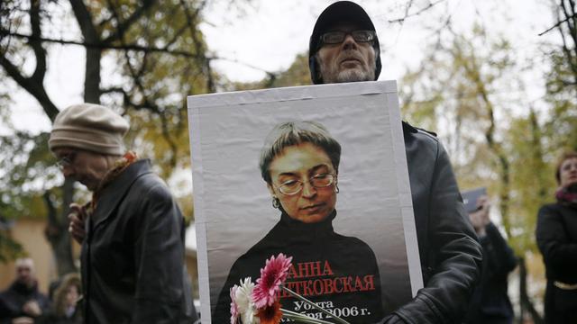 Ein Mann trägt ein Bild von Anna Politkowskaja