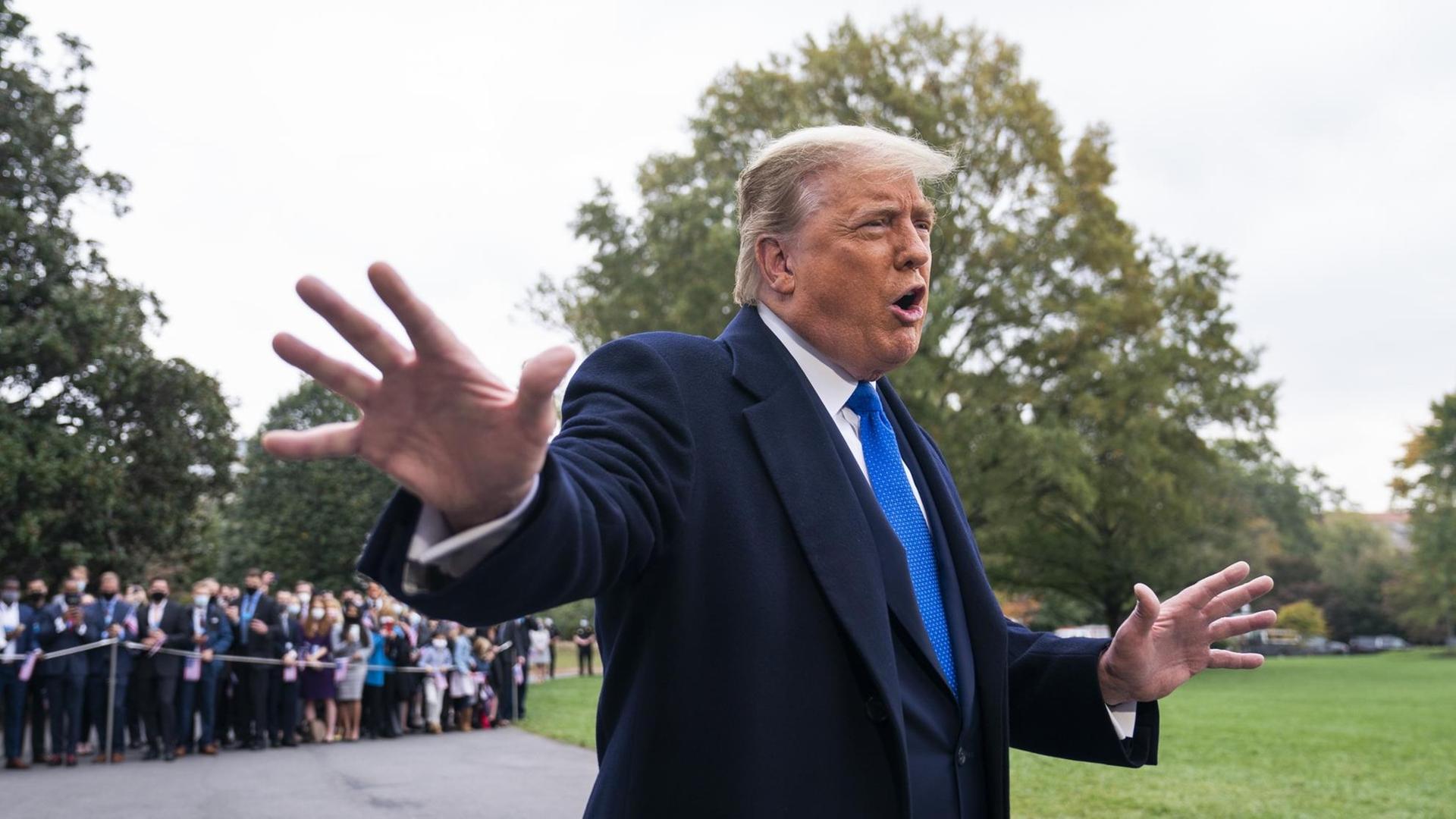 US-Präsident Donald Trump, gestikulierend vor einer Gruppe von Menschen. US-Präsident Donald Trump, gestikulierend vor einer Gruppe von Menschen.