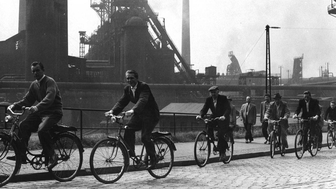 Feierabend! Arbeiter fahren mit dem Fahrrad an dem Hüttenwerk Oberhausen vorbei. Feierabend! Arbeiter fahren mit dem Fahrrad an dem Hüttenwerk Oberhausen vorbei.
