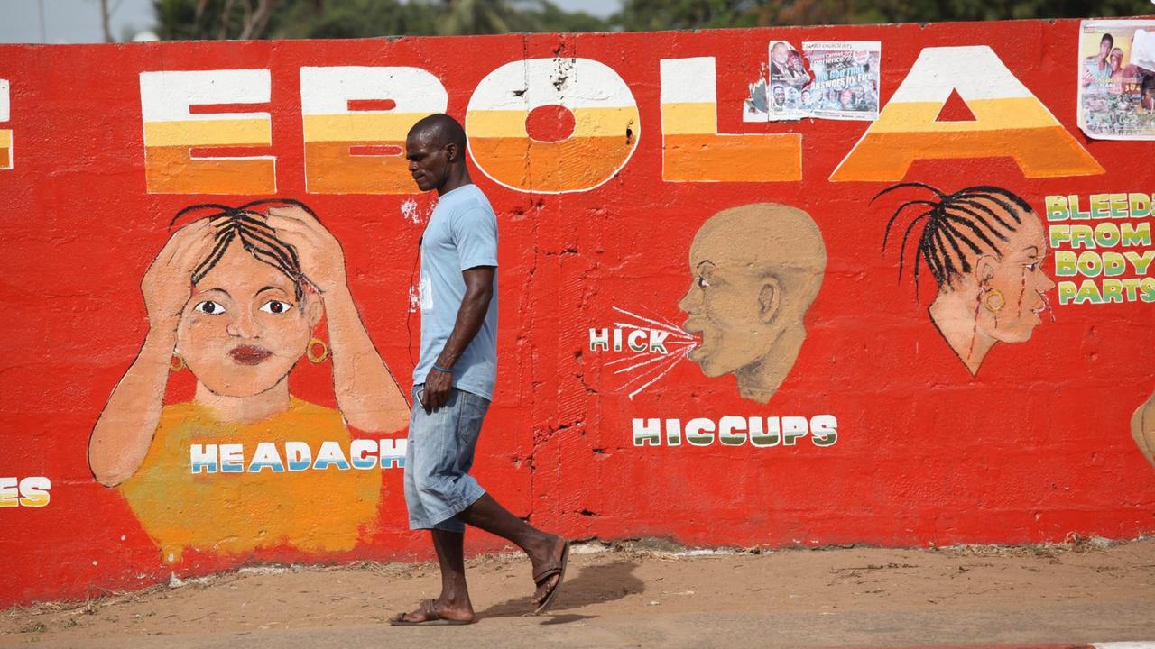 Ein Mann geht in Liberias Hauptstadt Monrovia an einer roten Wandmalerei vorbei, die vor dem Ebola-Virus warnt Ein Mann geht in Liberias Hauptstadt Monrovia an einer roten Wandmalerei vorbei, die vor dem Ebola-Virus warnt