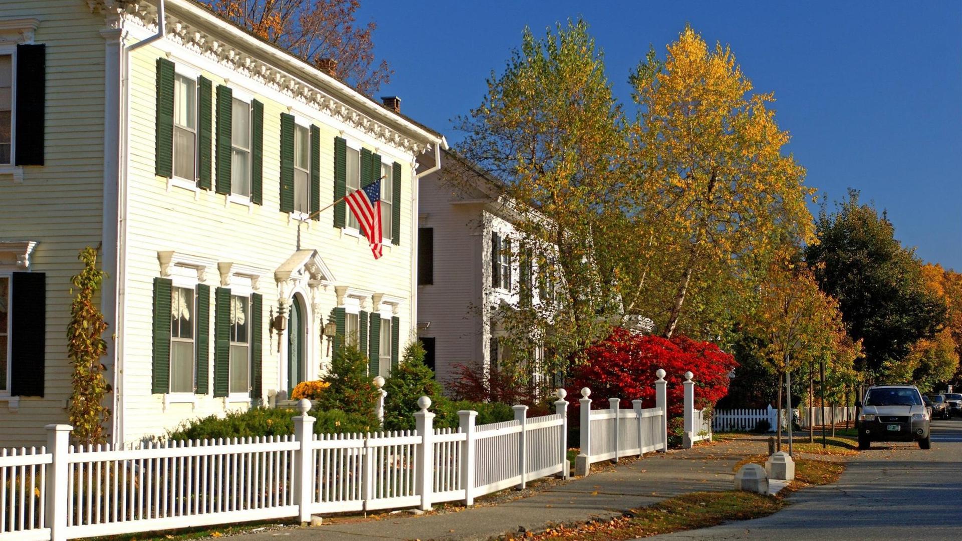 Das Foto zeigt eine typische amerikanische Kleinstadtidylle mit einer gehissten US-amerikanischen Flagge im Bundesstaat Vermont während des Indian Summer. Das Foto zeigt eine typische amerikanische Kleinstadtidylle mit einer gehissten US-amerikanischen Flagge im Bundesstaat Vermont während des Indian Summer.