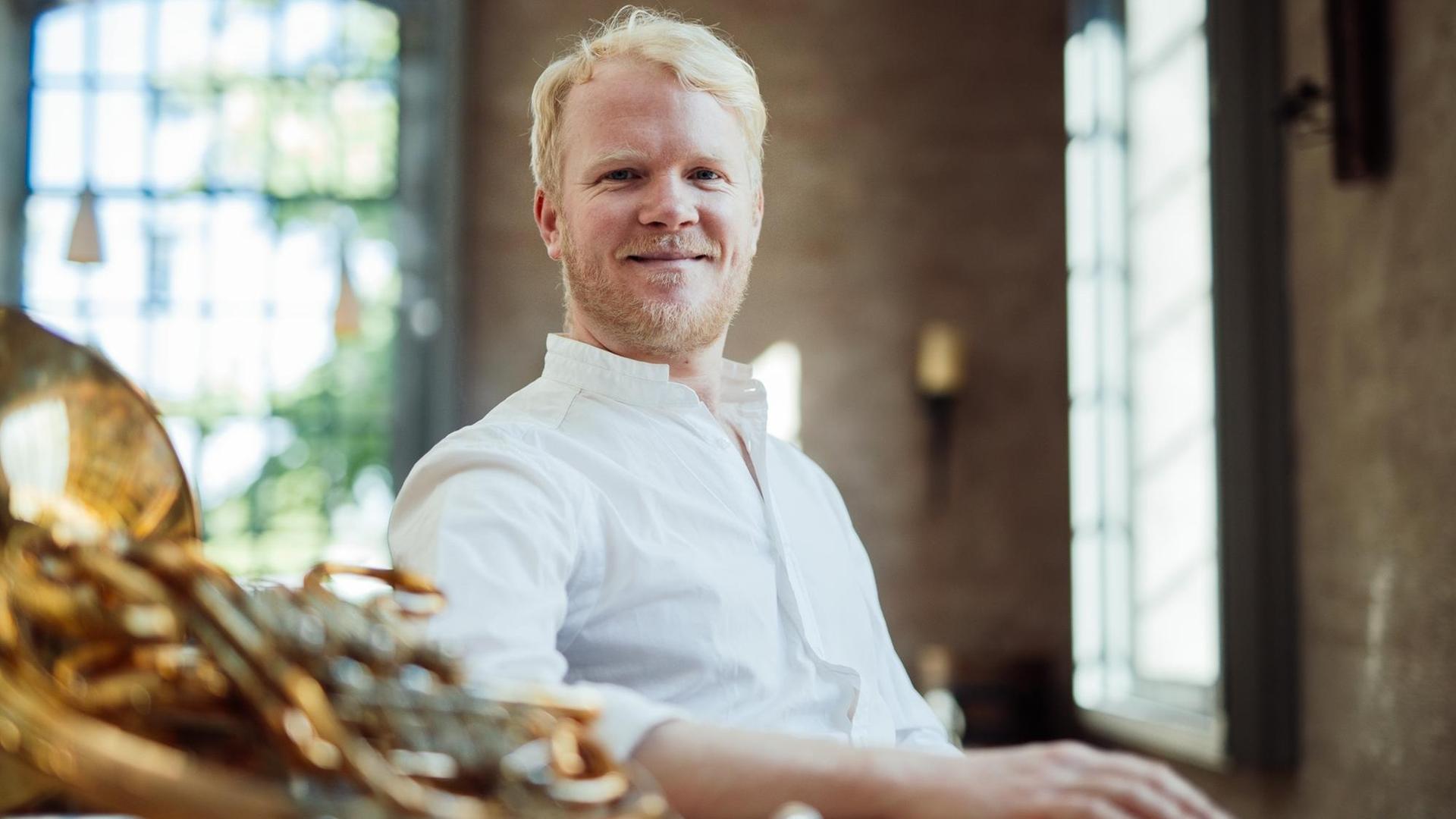 Porträt des Musikers, der an einem Tisch sitzt, auf dem sein Horn liegt. Porträt des Musikers, der an einem Tisch sitzt, auf dem sein Horn liegt.