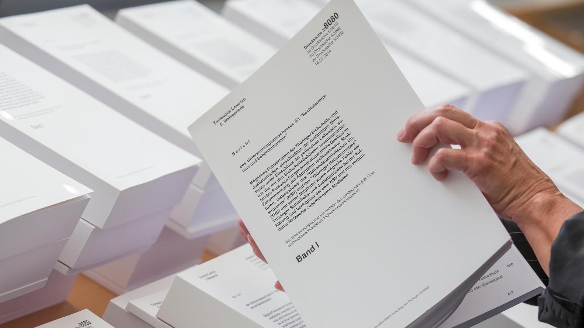 Eine Frau blättert am 21.08.2014 im Landtag in Erfurt im Abschlussbericht des Thüringer NSU-Untersuchungsausschusses. Eine Frau blättert am 21.08.2014 im Landtag in Erfurt im Abschlussbericht des Thüringer NSU-Untersuchungsausschusses.