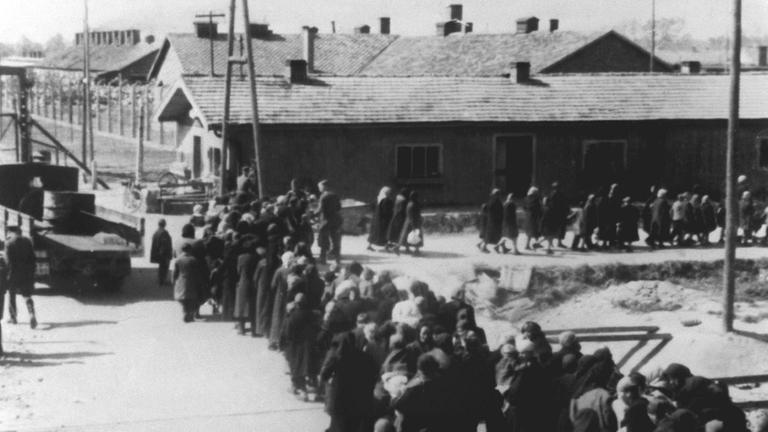 Ein Gruppe Häftlinge bewegt sich nach der Selektion zum Krematorium im KZ Auschwitz.