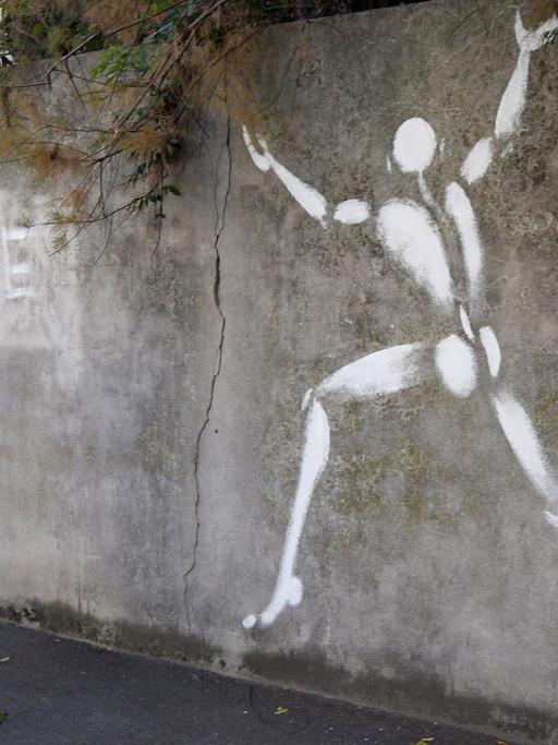 Der französische Künstler Jerome Mesnager geht an einem seiner Kunstwerke, dem "Mann in Weiß", in Montreuil-sous-Bois vorbei.