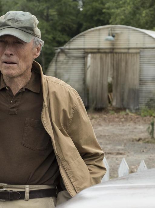 Das von der Filmfirma Warner Bros. Pictures veröffentlichte Bild zeigt Clint Eastwood in einer Szene in "The Mule". Er hat eine Schirmmütze auf, im Hintergrund sind Gewächshäuser zu sehen.