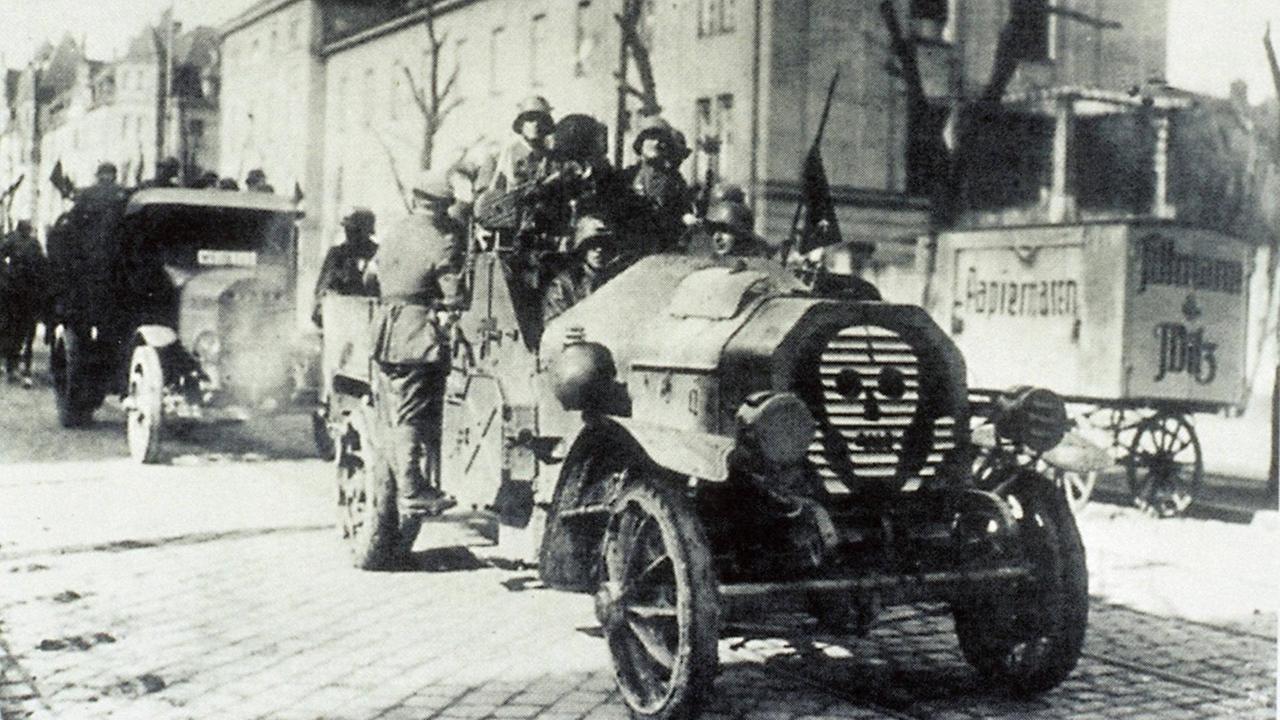 Eine Gruppe Männer in einem Wagen mit Totenkopf Symbol fahren als Freikorps auf den Straßen in Berlin in den 1920er Jahren. Eine Gruppe Männer in einem Wagen mit Totenkopf Symbol fahren als Freikorps auf den Straßen in Berlin in den 1920er Jahren.