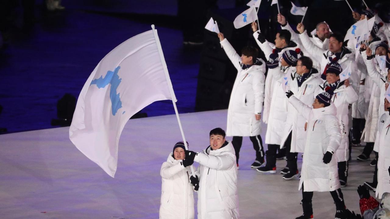 Won Yun Jong, Bobfahrer aus Südkorea, und Hwang Chung Gum, Eishockeyspielerin aus Nordkorea, halten bei der Eröffung der Olympischen Winterspiele 2018 in Pyeongchang gemeinsam eine Fahne mit den Umrissen eines geeinten Koreas Won Yun Jong, Bobfahrer aus Südkorea, und Hwang Chung Gum, Eishockeyspielerin aus Nordkorea, halten bei der Eröffung der Olympischen Winterspiele 2018 in Pyeongchang gemeinsam eine Fahne mit den Umrissen eines geeinten Koreas