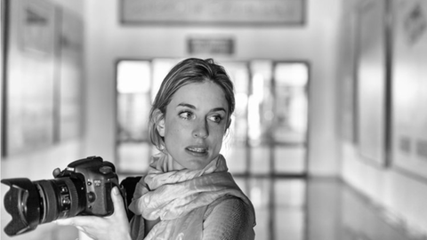 Julia Leeb posiert mit einer Kamera in der Hand für ein Foto.