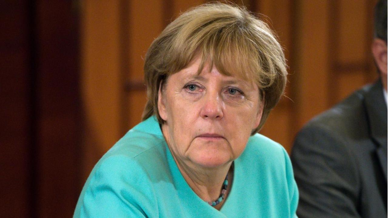 Bundeskanzlerin Angela Merkel (CDU) sitzt an einem Tisch. Bundeskanzlerin Angela Merkel (CDU) sitzt an einem Tisch.