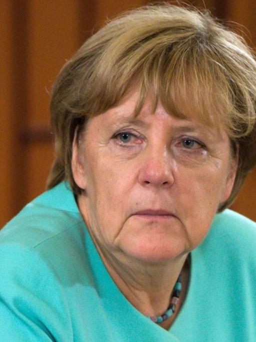 Bundeskanzlerin Angela Merkel (CDU) sitzt an einem Tisch.