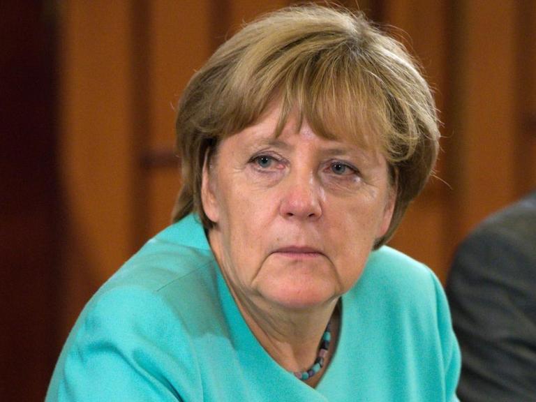 Bundeskanzlerin Angela Merkel (CDU) sitzt an einem Tisch.
