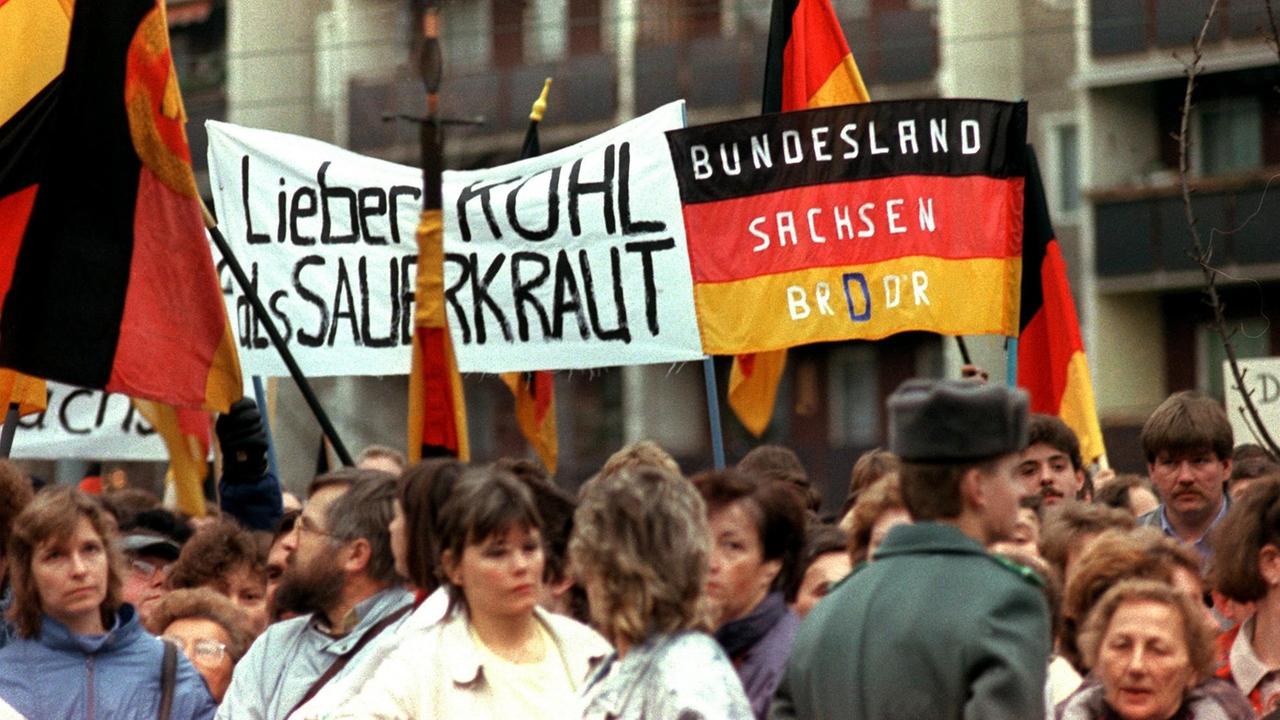 Dresdener Bürger tragen während einer Demonstration 1989 ein Transparent mit dem Spruch "Lieber Kohl als Sauerkraut".