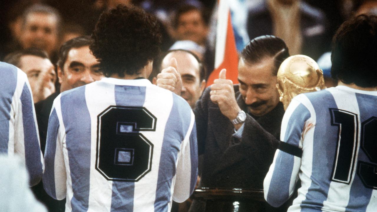 Der argentinische Junta-Chef, General Jorge Videla (2.v.r.), freut sich. Er überreicht bei der Siegerehrung am 25.06.1978 im River Plate-Stadion in Buenos Aires den WM-Pokal an Argentiniens Kapitän Daniel Passarella (r), der von seinem Teamgefährten Americo Gallego (Nr. 6) flankiert wird. Der argentinische Junta-Chef, General Jorge Videla (2.v.r.), freut sich. Er überreicht bei der Siegerehrung am 25.06.1978 im River Plate-Stadion in Buenos Aires den WM-Pokal an Argentiniens Kapitän Daniel Passarella (r), der von seinem Teamgefährten Americo Gallego (Nr. 6) flankiert wird.