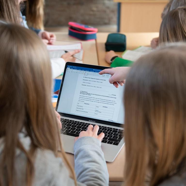 Schüler einer fünften Klasse eines Gymnasiums benutzen im Unterricht einen Laptop