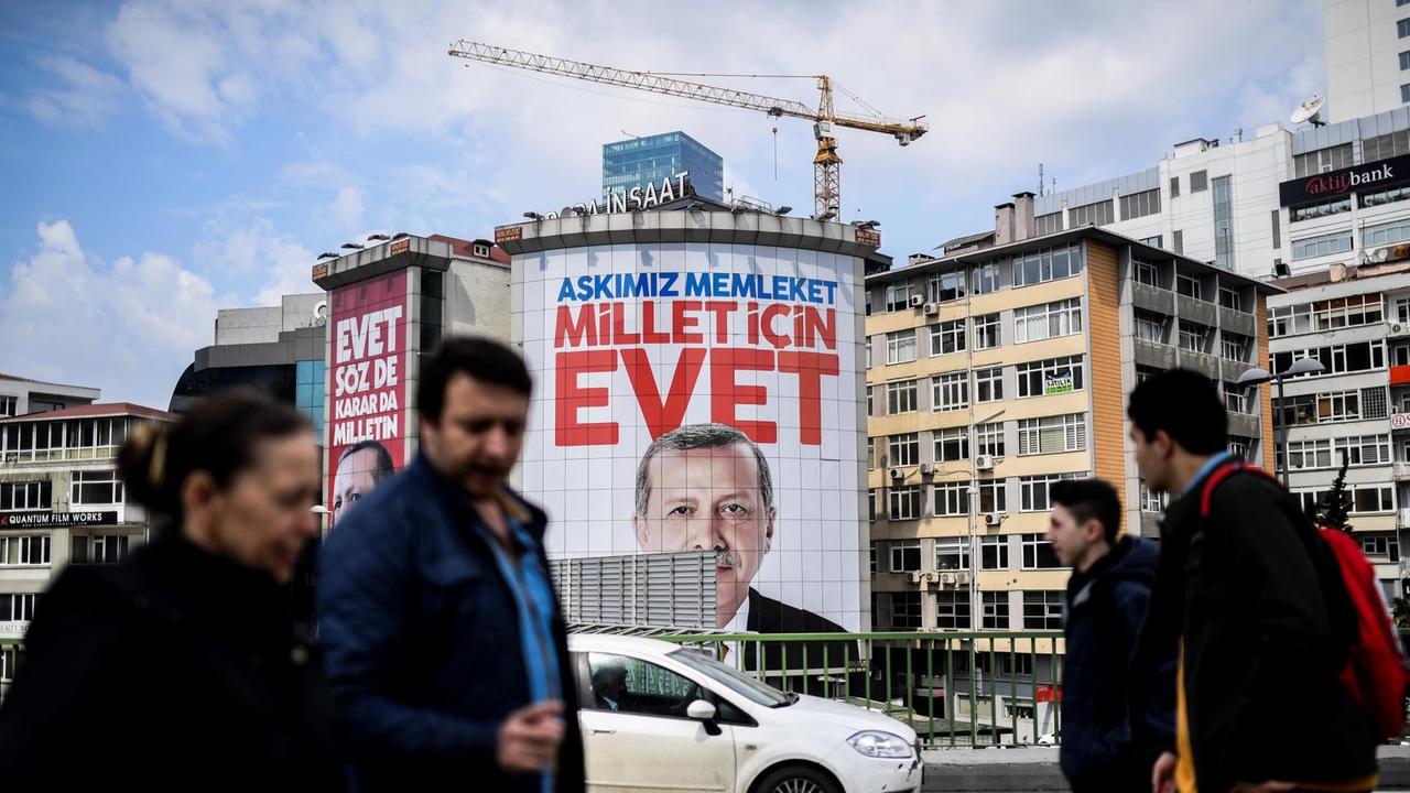 Menschen gehen vor einem riesigen Poster des türkischen Präsidenten Erdogan am 06.04.2017 in Istanbul Menschen gehen vor einem riesigen Poster des türkischen Präsidenten Erdogan am 06.04.2017 in Istanbul