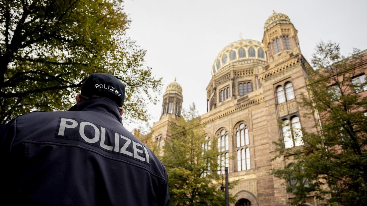 09.10.2019, Berlin: Ein Polizeibeamter läuft vor der Neuen Synagoge Berlin. 