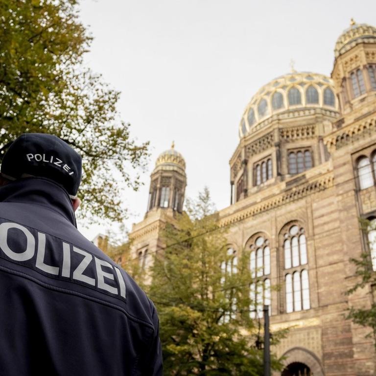 09.10.2019, Berlin: Ein Polizeibeamter läuft vor der Neuen Synagoge Berlin. 
