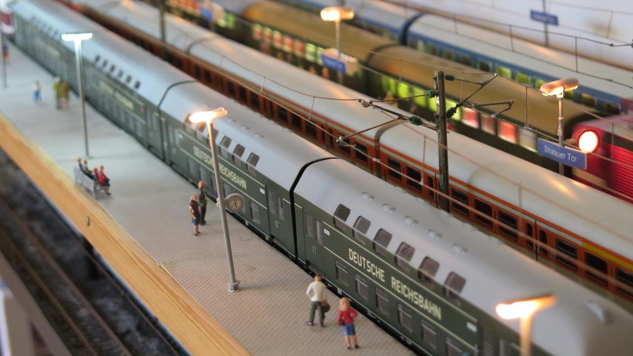 Die Figuren von Passagiere stehen an den Gleisen der Eisenbahnanlage. Die Figuren von Passagiere stehen an den Gleisen der Eisenbahnanlage.