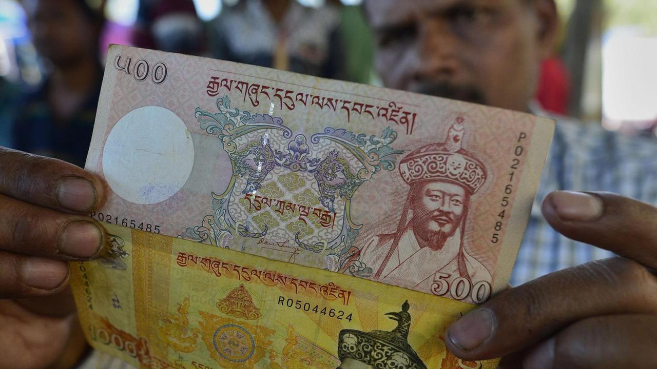 Ein indischer Händler im Bundesland Assam zeigt Geldscheine aus Bhutan. Ein indischer Händler im Bundesland Assam zeigt Geldscheine aus Bhutan.