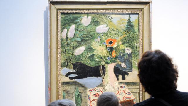 Besucher schauen sich in der Hamburger Kunsthalle das Bild "Stilleben mit Katze und Blumen" von Friedrich Ahlers-Hestermann aus dem Jahr 1931 an.