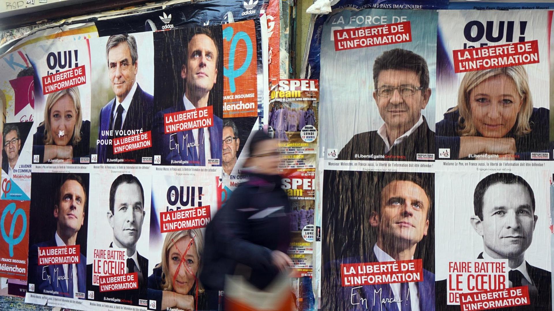 Wahlplakate am Montmartre in Paris, am 9. April 2017. Eine Frau läuft im Vordergrund vorbei. Wahlplakate am Montmartre in Paris, am 9. April 2017. Eine Frau läuft im Vordergrund vorbei.