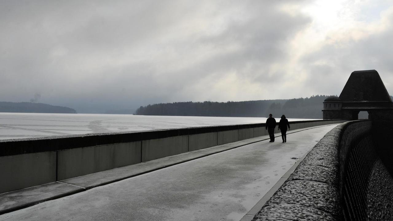 Zugefrorenes Sauerland: Zwei Spaziergänger laufen über die Staumauer Möhnesees. 