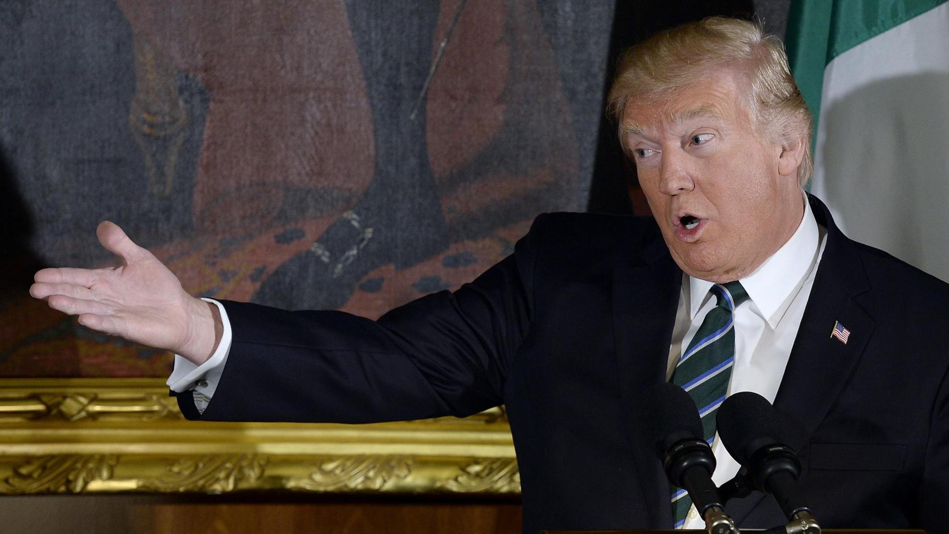 Trump bei einer Rede, den rechten Arm weit ausgestreckt. Trump bei einer Rede, den rechten Arm weit ausgestreckt.