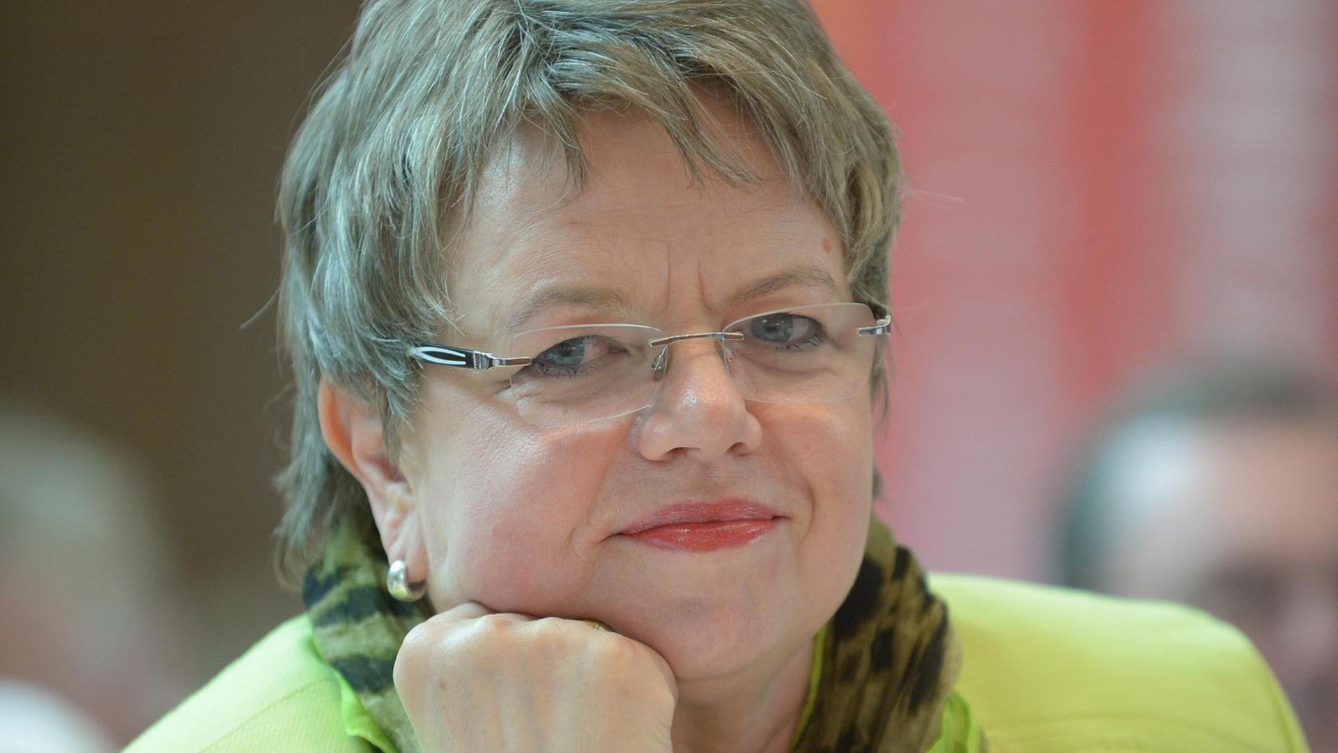 Porträt einer Frau in mittleren Jahren, sie ist stützt das Kinn in die Hand und lächelt. Porträt einer Frau in mittleren Jahren, sie ist stützt das Kinn in die Hand und lächelt.