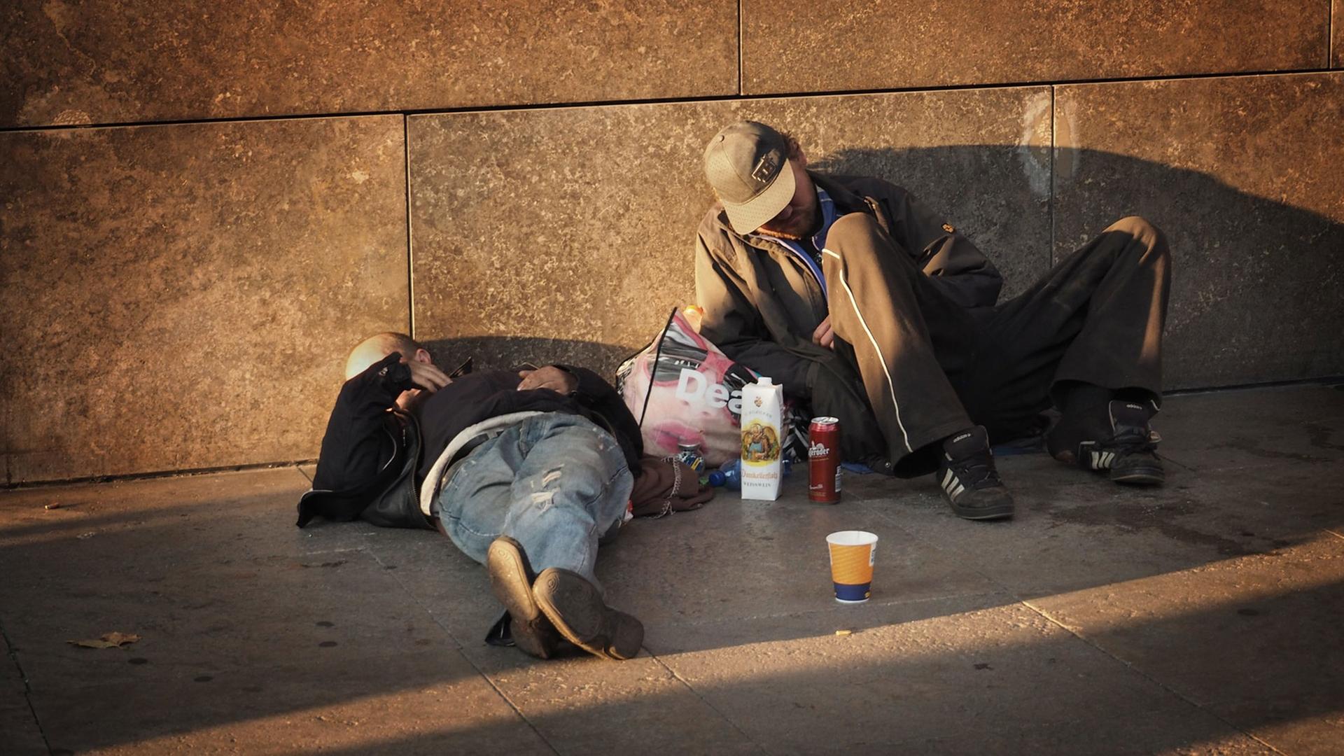 Zwei Obdachlose liegen auf einem Fußweg an einer Hauptstraße im Bezirk Mitte in Berlin am 04.10.2014. Zwei Obdachlose liegen auf einem Fußweg an einer Hauptstraße im Bezirk Mitte in Berlin am 04.10.2014.